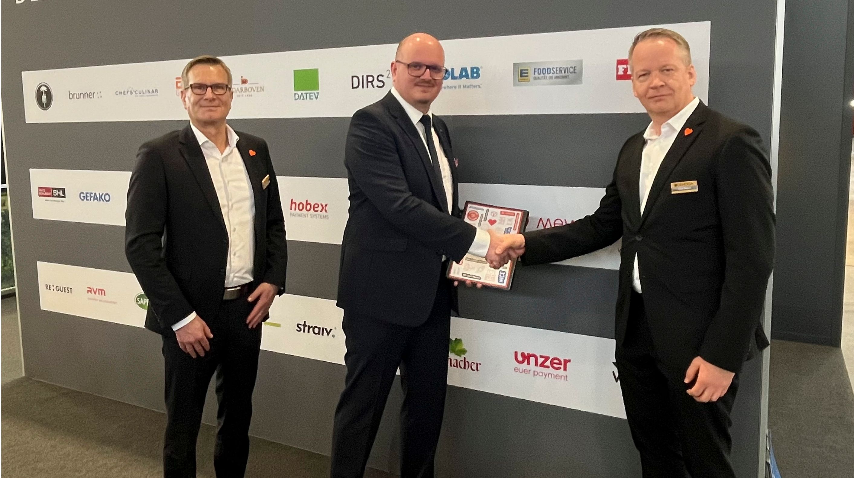 Tobias Zwiener (r.) und Michael Huber (l.), beide DEHOGA Baden-Württemberg, und Sebastian Lenk, Mewa, unterzeichneten auf der Intergastra den Vertrag. (Foto: Mewa)