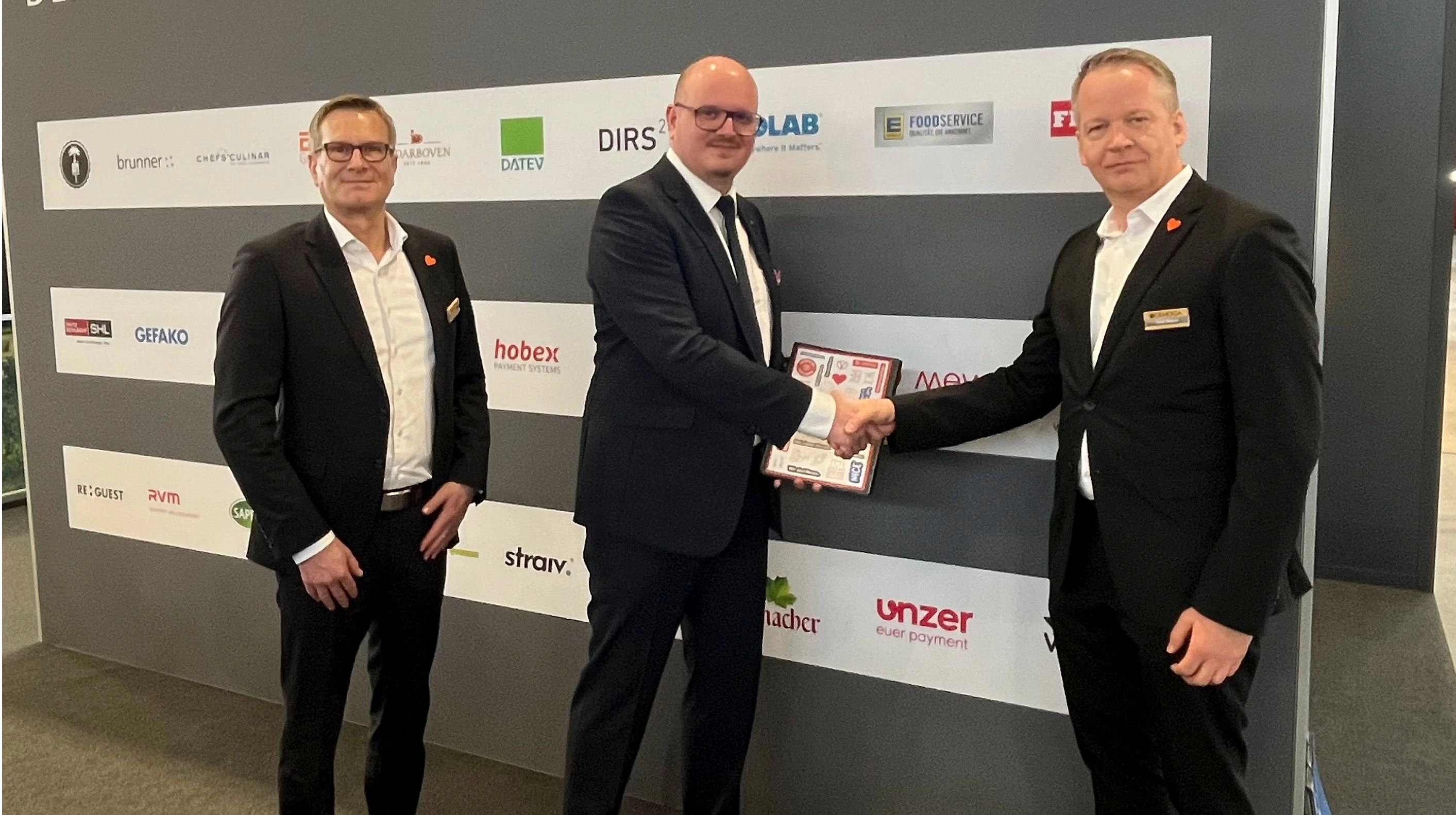 Tobias Zwiener (r.) und Michael Huber (l.), beide DEHOGA Baden-Württemberg, und Sebastian Lenk, Mewa, unterzeichneten auf der Intergastra den Vertrag. (Foto: Mewa)